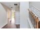 Bright hallway featuring hardwood floors and a staircase with white trim and a wooden banister at 841 Holly Meadow Dr, Buford, GA 30518