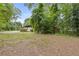 Wide shot of grassy backyard with detached garage and mature trees at 3614 N Druid Hills N Rd, Decatur, GA 30033