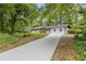 Well-kept white home with a long, newly paved driveway, surrounded by mature trees at 3614 N Druid Hills N Rd, Decatur, GA 30033