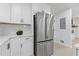 Close-up view of the kitchen featuring stainless steel refrigerator, marble countertops, and white cabinetry at 3614 N Druid Hills N Rd, Decatur, GA 30033