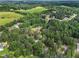 Expansive aerial view of a neighborhood featuring lush green trees and some houses in a rural setting at 385 Eagles Nest Cir, Carrollton, GA 30116