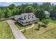 Aerial view of a long driveway leading to a two-story home with covered front porch and manicured lawn at 385 Eagles Nest Cir, Carrollton, GA 30116