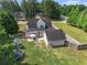Aerial view of the home's backyard with a patio, fire pit, play area, and wooded area beyond at 385 Eagles Nest Cir, Carrollton, GA 30116