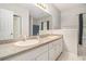 Bathroom with double sink vanity, tile flooring, large mirror and good lighting at 385 Eagles Nest Cir, Carrollton, GA 30116