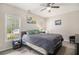 Bedroom with neutral walls and carpet featuring large bed, ceiling fan and natural light at 385 Eagles Nest Cir, Carrollton, GA 30116