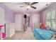 Bright bedroom with pastel purple walls, carpet, a twin bed, and a hall to more rooms at 385 Eagles Nest Cir, Carrollton, GA 30116