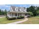 Charming two-story home featuring a covered front porch, mature landscaping, and manicured lawn at 385 Eagles Nest Cir, Carrollton, GA 30116