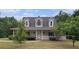 Charming home featuring a covered front porch, dormer windows, and mature landscaping at 385 Eagles Nest Cir, Carrollton, GA 30116