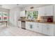 Bright kitchen with stainless steel appliances, white cabinets, and tile floors at 385 Eagles Nest Cir, Carrollton, GA 30116
