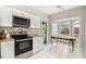 Bright kitchen features stainless steel appliances, granite countertops, and a cozy dining area at 385 Eagles Nest Cir, Carrollton, GA 30116