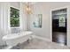 Bright bathroom with a freestanding tub, decorative light fixture, and a large window at 4085 Hillcrest View Ct, Suwanee, GA 30024