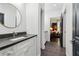Bathroom featuring a vanity with a dark countertop, round mirror, and modern fixtures at 4085 Hillcrest View Ct, Suwanee, GA 30024