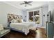 Comfortable bedroom featuring hardwood floors, large windows, sitting area and unique decorative headboard at 4085 Hillcrest View Ct, Suwanee, GA 30024