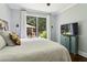 Bright bedroom featuring a queen bed, window, wood floors, and modern design elements at 4085 Hillcrest View Ct, Suwanee, GA 30024