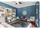 Charming blue bedroom with built-in bookshelves, decorative rug, ceiling fan, and sunny sitting area at 4085 Hillcrest View Ct, Suwanee, GA 30024