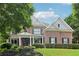 Charming two-story brick home with a landscaped front yard, dark shutters, and a welcoming covered porch entry at 4085 Hillcrest View Ct, Suwanee, GA 30024