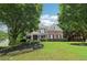 Elegant two-story brick home with professionally landscaped yard, dark shutters, and inviting covered entry at 4085 Hillcrest View Ct, Suwanee, GA 30024