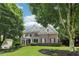 Attractive brick home with black shutters, a landscaped yard, and a partial view behind mature trees at 4085 Hillcrest View Ct, Suwanee, GA 30024