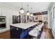 Open kitchen with large island, stainless appliances, seating, and hardwood floors that transitions into living area at 4085 Hillcrest View Ct, Suwanee, GA 30024