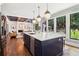Bright kitchen with navy island, quartz countertops, stainless appliances, and a view to the outdoor living space at 4085 Hillcrest View Ct, Suwanee, GA 30024
