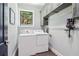 Bright laundry room with gray cabinets, hanging rod, window, and a washer/dryer set at 4085 Hillcrest View Ct, Suwanee, GA 30024