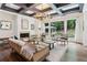 Stylish living room with coffered ceiling, fireplace, and large windows showcasing the serene outdoor scenery at 4085 Hillcrest View Ct, Suwanee, GA 30024