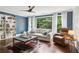 A cozy living room featuring custom shelves, large windows, and elegant furniture at 4085 Hillcrest View Ct, Suwanee, GA 30024