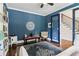Stylish blue office with a patterned rug and doorway leading to staircase at 4085 Hillcrest View Ct, Suwanee, GA 30024