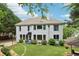 Back of the home with a basketball hoop, mature trees, and a lush green lawn at 4085 Hillcrest View Ct, Suwanee, GA 30024
