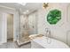 Bright bathroom featuring a soaking tub, glass shower, and geometric window providing natural light at 5524 Wedgewood Sw Ct, Lilburn, GA 30047