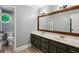 Bathroom featuring a double vanity with a dark cabinet and framed mirror plus a separate water closet at 5524 Wedgewood Sw Ct, Lilburn, GA 30047