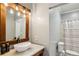 Well-lit bathroom features a vessel sink, modern vanity, and shower with glass door at 5524 Wedgewood Sw Ct, Lilburn, GA 30047