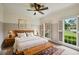 Cozy bedroom with neutral tones, shutters, ceiling fan, and a decorative rug at 5524 Wedgewood Sw Ct, Lilburn, GA 30047