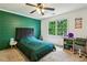 Stylish bedroom with a green accent wall, plush bed, and a desk near a bright window at 5524 Wedgewood Sw Ct, Lilburn, GA 30047