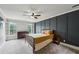 Well-lit bedroom with a gray accent wall, a wooden bed frame, and windows with shuttered blinds at 5524 Wedgewood Sw Ct, Lilburn, GA 30047
