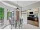 Sunlit breakfast nook with glass table and chairs, connecting to both a screened-in porch and living room at 5524 Wedgewood Sw Ct, Lilburn, GA 30047