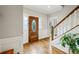 Bright foyer showcasing hardwood floors, decorative front door with glass panels, and staircase at 5524 Wedgewood Sw Ct, Lilburn, GA 30047