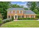 Charming brick home featuring a well-manicured lawn, neat landscaping, and classic colonial architecture at 5524 Wedgewood Sw Ct, Lilburn, GA 30047