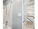 Hallway showing a white tiled shower with a glass door, leading to carpeted stairs at 5524 Wedgewood Sw Ct, Lilburn, GA 30047
