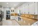 Well-lit kitchen features white cabinets, granite countertops, stainless steel appliances, and tile backsplash at 5524 Wedgewood Sw Ct, Lilburn, GA 30047