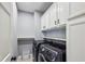 Efficient laundry room featuring a side-by-side washer and dryer set and ample shelving space at 5524 Wedgewood Sw Ct, Lilburn, GA 30047