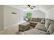 Cozy living room with a large sectional sofa, soft carpeting, and natural light from the window at 5524 Wedgewood Sw Ct, Lilburn, GA 30047