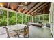 Inviting screened porch with cozy seating, a dining table, and views of lush greenery at 5524 Wedgewood Sw Ct, Lilburn, GA 30047