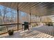 Covered back deck with grill, stained wood floors, and a metal roof at 735 Amberton Close, Suwanee, GA 30024