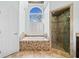Elegant bathroom features a soaking tub, a separate shower and a large window at 735 Amberton Close, Suwanee, GA 30024