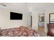 Bedroom features a mounted television, dresser and view into the bathroom at 735 Amberton Close, Suwanee, GA 30024