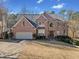 Traditional brick home with a well manicured lawn and mature landscaping for great curb appeal at 735 Amberton Close, Suwanee, GA 30024