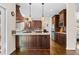 Spacious kitchen island with dark wood cabinets, granite countertops, and modern lighting at 735 Amberton Close, Suwanee, GA 30024