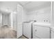 Bright laundry room with side-by-side washer and dryer units and a wire rack for storage at 113 Tuxworth Cir, Decatur, GA 30033