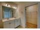 Well-lit bathroom featuring double sinks and a walk-in closet at 2929 Rambler Dr, Loganville, GA 30052